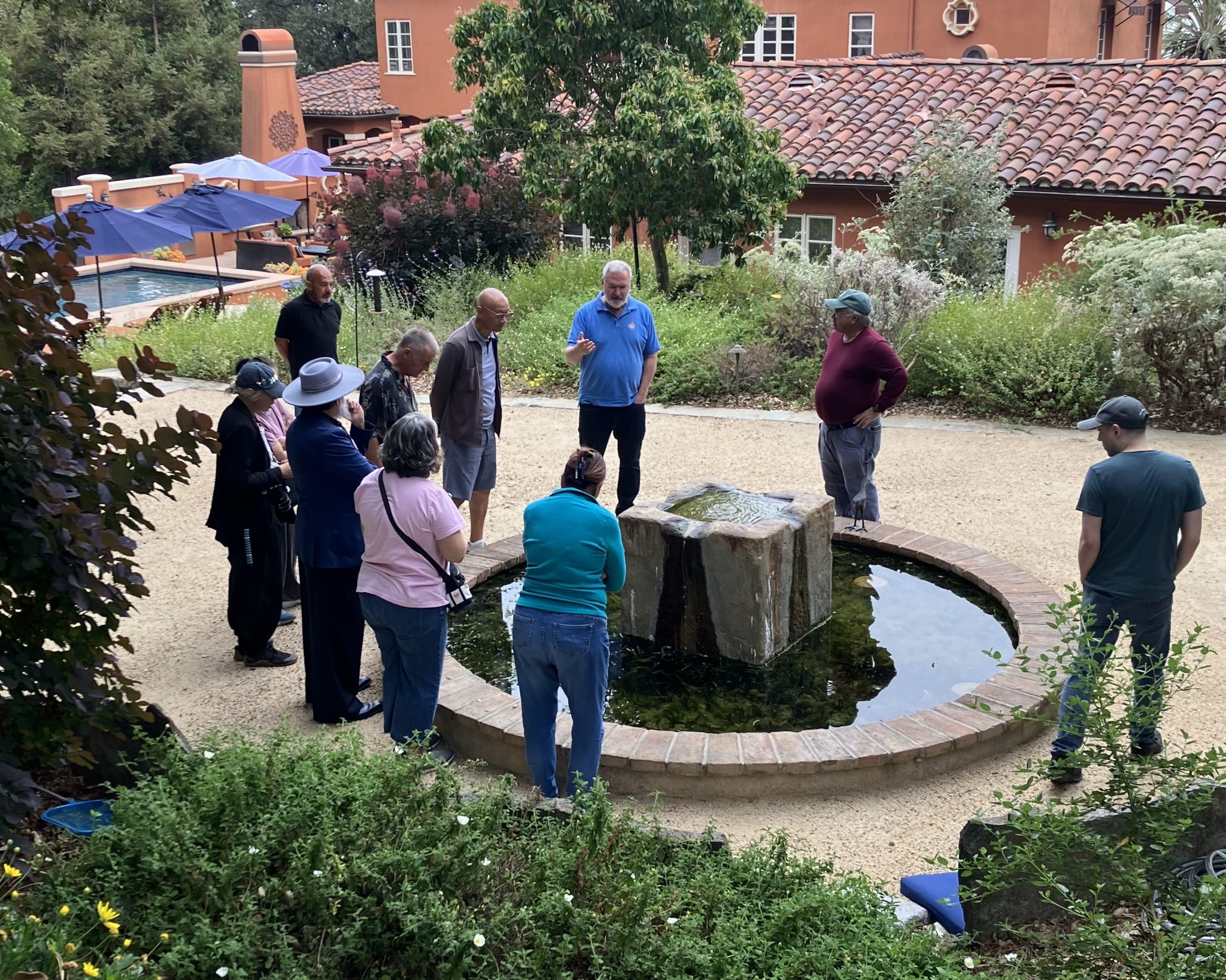 Members gathered around a fountain on a member garden tour